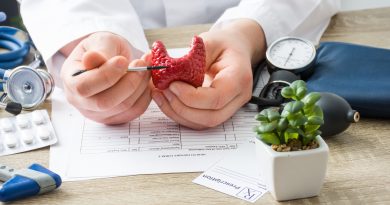 At doctors appointment physician shows to patient shape of thyroid gland with focus on hand with organ. Scene explaining patient causes and localization of diseases of thyroid and endocrine system