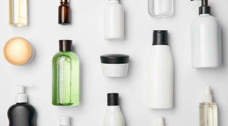 Top view of different cosmetic bottles and container on white background