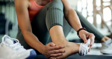 Woman holding foot at gym.