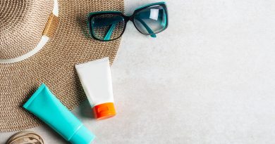 Sunscreen products on grey background, flat lay. Spring and summer protection against the Sun