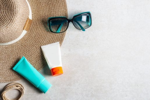 Sunscreen products on grey background, flat lay. Spring and summer protection against the Sun