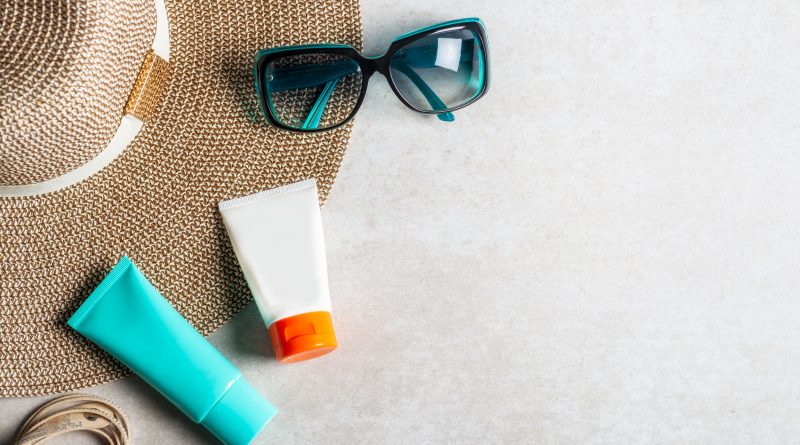 Sunscreen products on grey background, flat lay. Spring and summer protection against the Sun