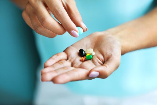 Hand holding vitamins.