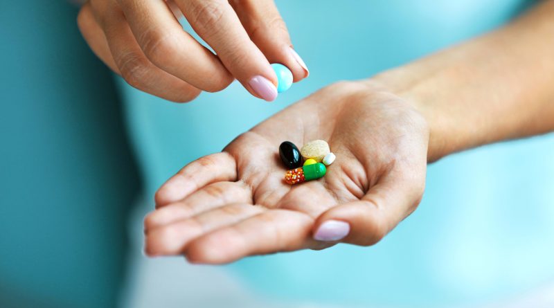 Hand holding vitamins.