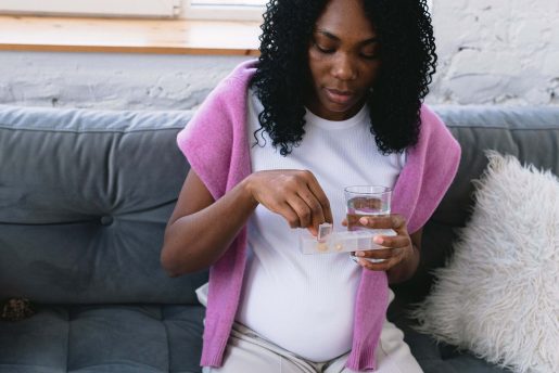Pregnant woman taking prenatal vitamins.