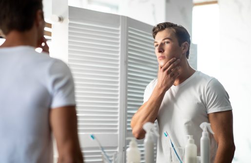 Young man looking in the mirror.