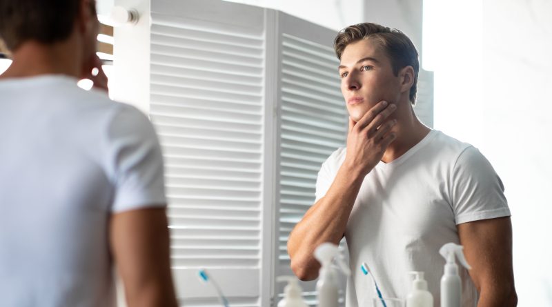 Young man looking in the mirror.