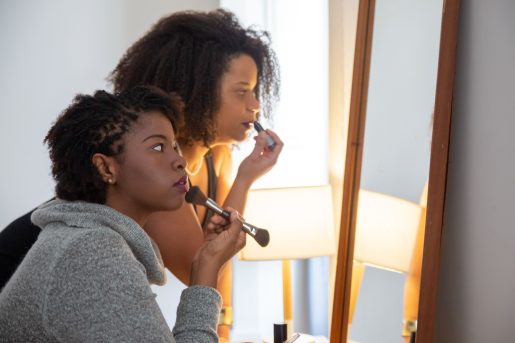 Two women doing makeup.