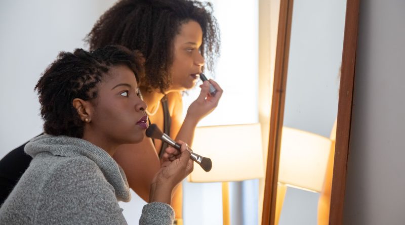 Two women doing makeup.