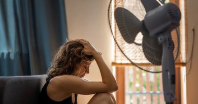 Woman sitting under fan.