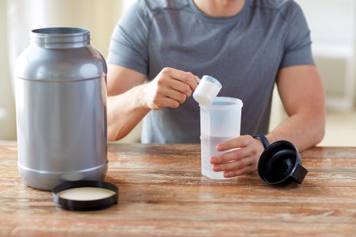 Man with protein shake bottle and jar.