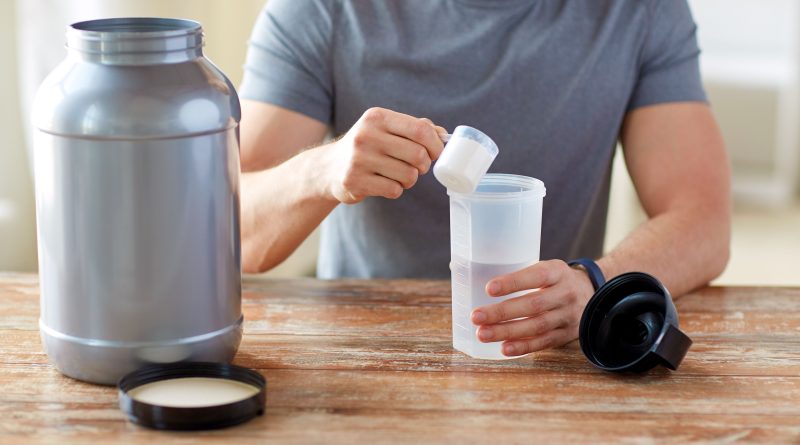 Man with protein shake bottle and jar.