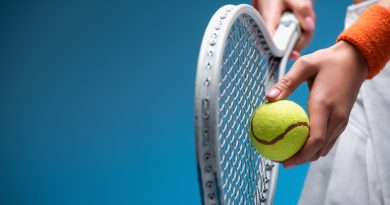Person holding tennis racket and ball.